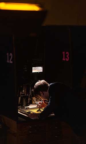 Oakton student, Julian Ozers, working over a drafting table.